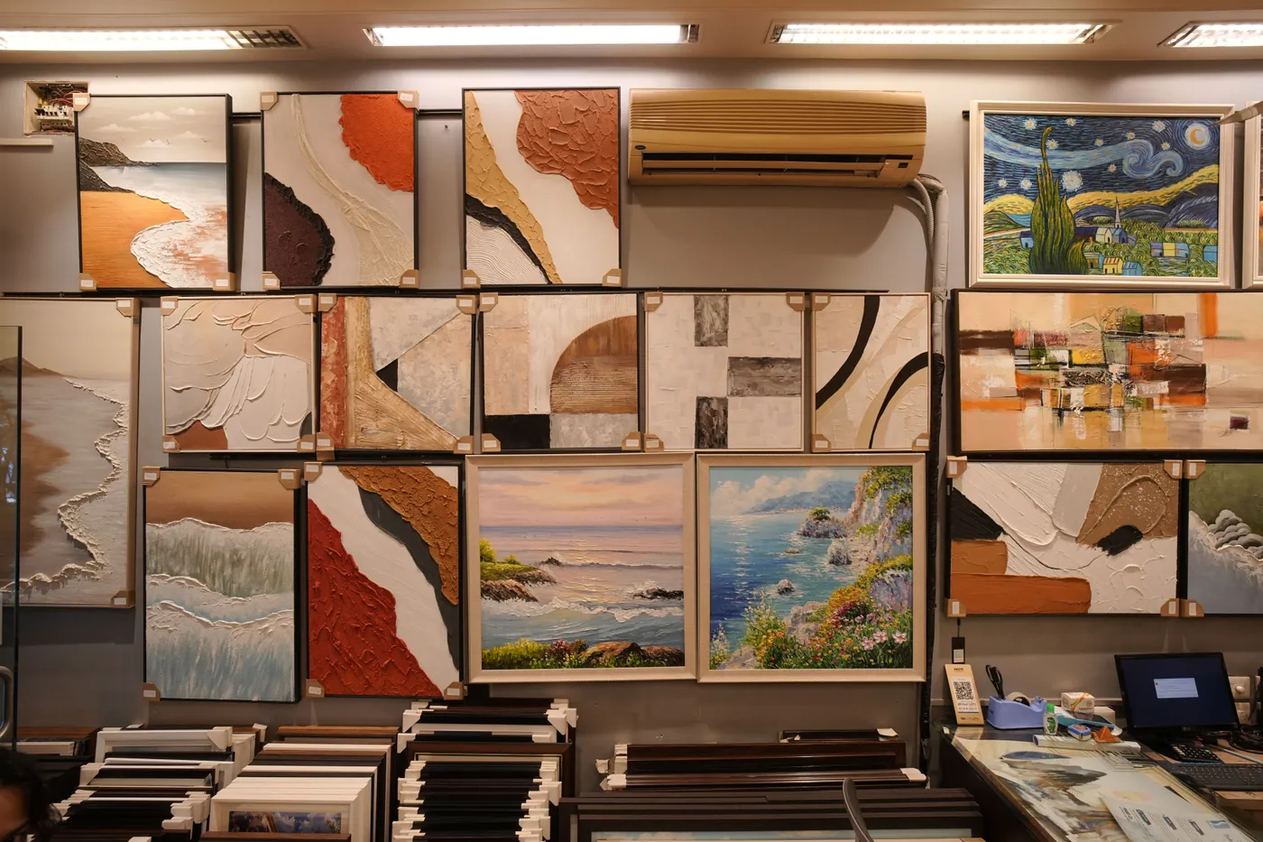 Framed abstract works filling a showroom wall